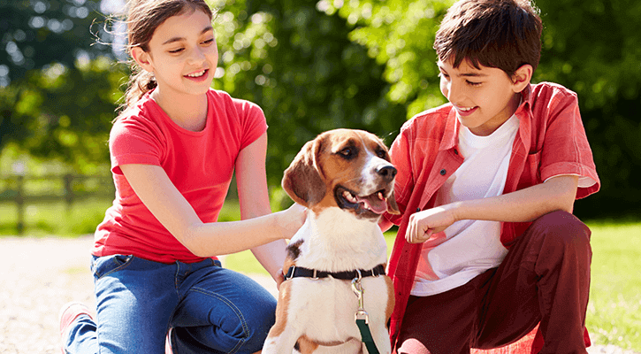 Two children sitting with their dog